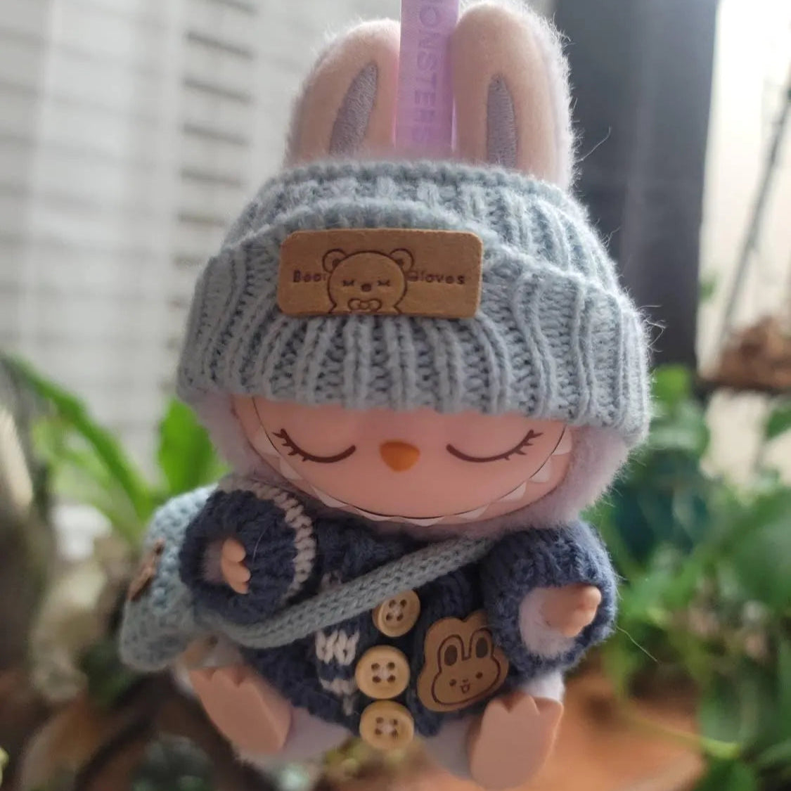 Plush toy with a knitted hat and sweater on a blurred background